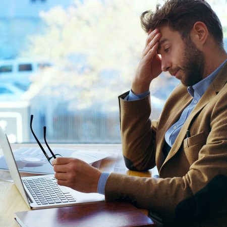 Cropped shot of a young businessman looking stressed while working in the office